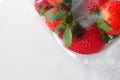 Ripe strawberries in a plastic package on a white background. Delicious fresh berries in a container for sale to Royalty Free Stock Photo