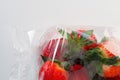 Ripe strawberries in a plastic package on a white background. Delicious fresh berries in a container for sale to Royalty Free Stock Photo