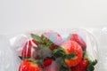 Ripe strawberries in a plastic package on a white background. Delicious fresh berries in a container for sale to Royalty Free Stock Photo