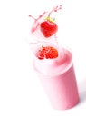 Ripe strawberries splashing into fruit smoothie Royalty Free Stock Photo