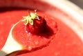 Ripe strawberries in a wooden spoon on the background of strawberry jam Royalty Free Stock Photo