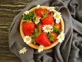 Ripe strawberry, chamomile flower on wooden backgrou