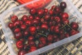 Ripe sweet cherries in a boxing box on a bedspread on the beach. Cherry season in early summer. Ripe berries. Organic food.