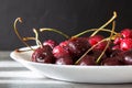 Ripe sweet cherries in a white plate on the table. Royalty Free Stock Photo