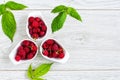 Ripe sweet and fresh raspberries in a white ceramic bowl with leaves Royalty Free Stock Photo