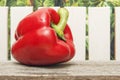 Ripe sweet pepper on wooden table and on fence background closeup. Copy space for text or design Royalty Free Stock Photo
