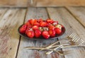 Ripe and sweet strawberries in a black plate on a wooden table Royalty Free Stock Photo