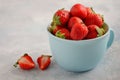 Ripe sweet strawberries in blue cup on blue concrete background. Royalty Free Stock Photo