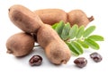 Ripe tamarind fruit, leaves and some tamarind seeds isolated on white background