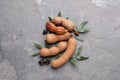Ripe tamarinds and fresh leaves on grey table, flat lay Royalty Free Stock Photo