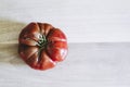 Ripe tomato of crimean black variety lying on a wooden table