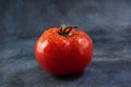 Ripe tomato with drops views on grunge background.