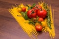 Ripe tomatoes and cherry with mint, rosemary and dill on spaghetti on a wooden background Royalty Free Stock Photo