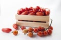 Ripe tomatoes on lie in a wooden box on a white background,, Royalty Free Stock Photo