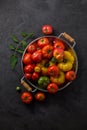 Ripe tomatoes in a pan on black stone background, copy space Royalty Free Stock Photo