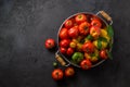 Ripe tomatoes in a pan on black stone background, copy space Royalty Free Stock Photo