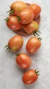 Ripe tomatoes on a plate and scattered on table top Royalty Free Stock Photo