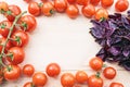 Ripe tomatoes and purple basil on a wooden table form frame for