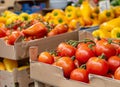 Ripe tomatoes and yellow peppers in cardboard boxes at the market, close up. On vines, blurred background of vegetables Royalty Free Stock Photo