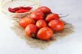 RIPE TREE TOMATO FRUIT ON A WHITE BACKGROUND WITH FRUIT OA PIECE OF HESSIAN AND RED CHILIS IN A GAUZE BASKET Royalty Free Stock Photo
