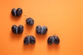 Ripe ugly plums. Fused prunes on a orange background. Space for text. Concept - reduction in vegetable or food waste