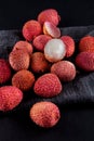 Ripe, vermilion exotic lichees decorated on a slate plate kitchen table background with napkin