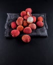 Ripe, vermilion exotic lichees decorated on a slate plate kitchen table background with napkin