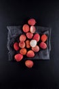 Ripe, vermilion exotic lichees decorated on a slate plate kitchen table background with napkin