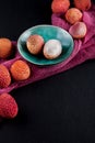 Ripe, vermilion exotic lichees decorated on a slate plate kitchen table background with napkin