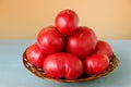 Ripe very large tomatoes in a wooden basket on a colored background Royalty Free Stock Photo