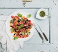 Ripe village heirloom tomato salad with olive oil and basil over light blue wooden background Royalty Free Stock Photo