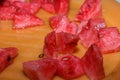 Ripe watermelon cut into pieces on an orange plate