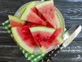 Ripe watermelon piece, plate portion summer organic dessert on a black wooden background natural Royalty Free Stock Photo
