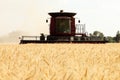 A ripe wheat field being harvested by a combine harvester.