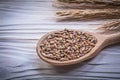 Ripe wheat and rye ears wooden spoon corn crop on wood board