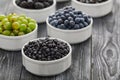 ripe wild berries blackberries, black currants and blueberries in bowls