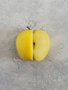Ripe yellow apple on a gray concrete background. Royalty Free Stock Photo