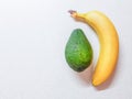 Ripe yellow banana and avocado on the white marble table