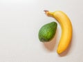 Ripe yellow banana and avocado on the white marble table