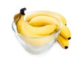 Ripe yellow bananas lie in a clear glass deep plate