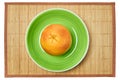 Ripe yellow grapefruit on a green plate on a cane serving mat