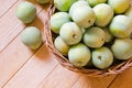 Ripe yellow-green plums in a wicker basket on a wooden table Royalty Free Stock Photo
