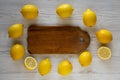 Ripe Yellow Organic Lemons and rustic board on a white wooden background, overhead view. Flat lay, top view, from above Royalty Free Stock Photo