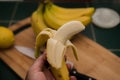 Ripe yellow peeled banana in a man`s hand Royalty Free Stock Photo