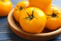 Ripe yellow tomatoes on wooden plate, closeup Royalty Free Stock Photo