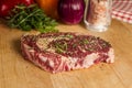 Ripened seasoned beef rib eye or entrecote steak on wooden cut board prepared for cooking