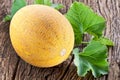 Ripes melon with melon leaves on wooden background. Royalty Free Stock Photo