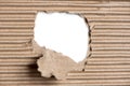 Ripped hole in brown cardboard on white background Royalty Free Stock Photo