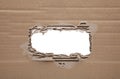 Ripped hole in cardboard on white background. Royalty Free Stock Photo