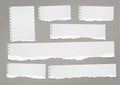 Ripped lined notebook paper strips for text or message stuck on dark gray background.